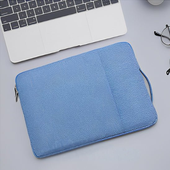 housse ordinateur 13 pouces bleue posee sur plan de travail avec ordinateur portable ouvert et lunettes