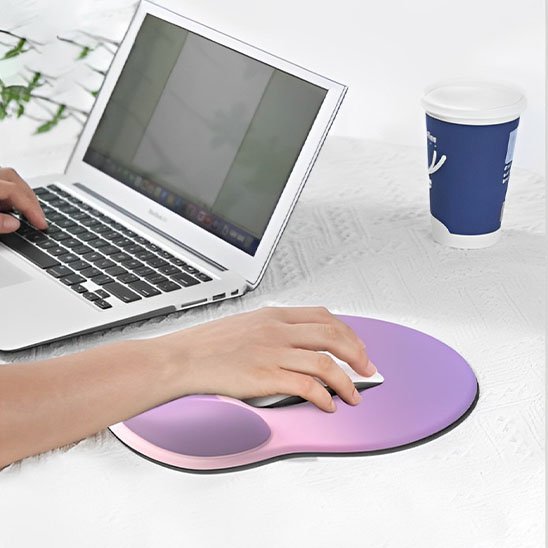 tapis de souris ergonomique rose et violet avec souris tenu par main et ordinateur portable