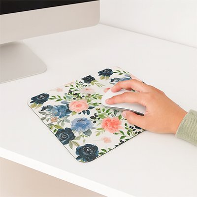 tapis souris floral avec main dirigeant souris sur surface blanche