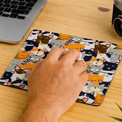 personne tenant souris sur tapis souris multichat devant ordinateur portable